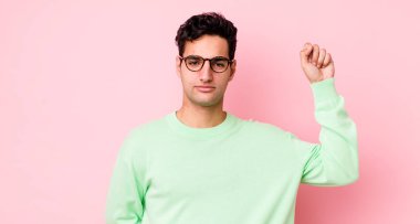 Yakışıklı İspanyol adam ciddi, güçlü ve asi hissediyor, yumruğunu kaldırıyor, protesto ediyor ya da devrim için savaşıyor.