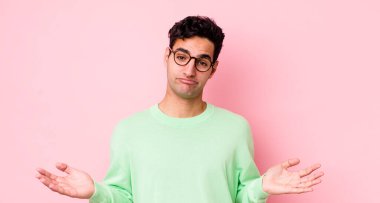 Yakışıklı İspanyol adam şaşkın ve şaşkın hissediyor, doğru cevap veya karardan emin değil, bir seçim yapmaya çalışıyor.