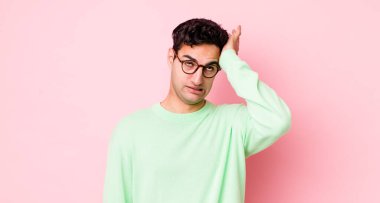 handsome hispanic man raising palm to forehead thinking oops, after making a stupid mistake or remembering, feeling dumb