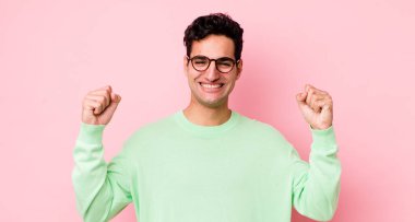 Yakışıklı İspanyol adam mutlu, pozitif ve başarılı hissediyor, zaferi, başarıları ya da iyi şansı kutluyor.