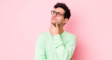 Yakışıklı İspanyol adam düşünceli, meraklı ya da hayal kuruyor, hayal kuruyor ve uzayı taklit etmeye çalışıyor.