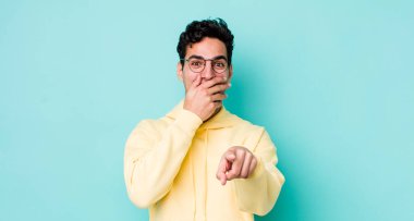 Yakışıklı İspanyol adam sana gülüyor, kamerayı gösteriyor ve seninle dalga geçiyor ya da alay ediyor.