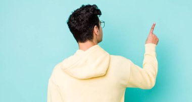 Yakışıklı İspanyol adam dikiz aynası ve fotokopi alanındaki objeyi işaret ediyor.