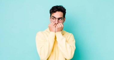 Yakışıklı İspanyol adam endişeli, stresli ve korkmuş görünüyor, tırnak yiyor ve yanal fotokopi alanı arıyor.