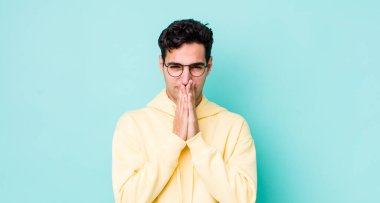 Yakışıklı İspanyol bir adam endişeli, umutlu ve dindar, sadık bir şekilde avuç içiyle dua ediyor, af diliyor.