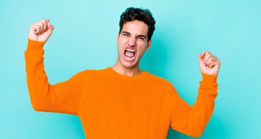 Yakışıklı İspanyol adam zaferle bağırıyor. Heyecanlı, mutlu ve şaşırmış görünüyor. Kutlama yapıyor.