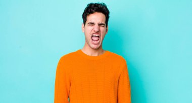 Yakışıklı İspanyol adam agresif bir şekilde bağırıyor, çok kızgın, sinirli, öfkeli ya da sinirli görünüyor, hayır