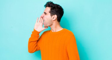 Yakışıklı İspanyol adam öfkeyle bağırıyor kenardaki boşluğu kopyalamak için, eli ağzının yanında