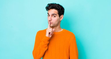 Yakışıklı İspanyol adam sessizlik ve sessizlik istiyor, parmaklarıyla ağzının önünde işaret ediyor, 