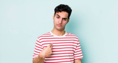 Yakışıklı İspanyol adam şaşkın, şaşkın ve güvensiz hissediyor, kendini gösterip kim olduğunu soruyor, ben mi??