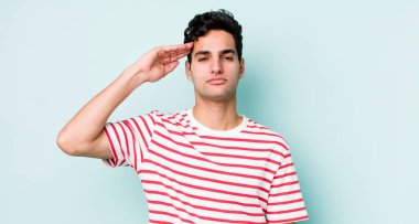 Yakışıklı İspanyol bir adam saygı göstererek, onur ve vatanseverlik adına kameraya selam veriyor.