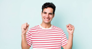 Yakışıklı İspanyol adam mutlu, pozitif ve başarılı hissediyor, zaferi, başarıları ya da iyi şansı kutluyor.