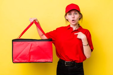 Kızıl saçlı güzel kadın şok olmuş ve ağzı açık, kendini işaret eden bir şekilde şaşırmış görünüyor. Pizza dağıtımı kavramı