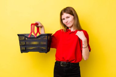 Kızıl saçlı güzel kadın kibirli, başarılı, pozitif ve gururlu görünüyor. Alışveriş sepeti konsepti