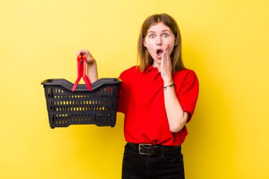 Kızıl saçlı güzel kadın şok olmuş ve korkmuş hissediyor. Alışveriş sepeti konsepti