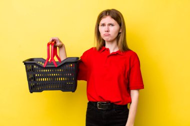 Kızıl saçlı, güzel bir kadın üzgün ve mızmızlanıyor. Mutsuz bir bakışı var ve ağlıyor. Alışveriş sepeti konsepti