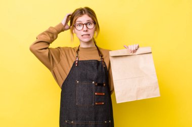 Kızıl saçlı güzel kadın stresli, endişeli ya da korkmuş, elleri başının üstünde. teslimat paket servis kavramı