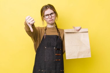 Kızıl saçlı, güzel bir kadın kendini kötü hissediyor, baş parmağını kaldırıyor. teslimat paket servis kavramı