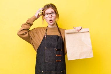 Kızıl saçlı güzel kadın mutlu, şaşkın ve şaşırmış görünüyor. teslimat paket servis kavramı