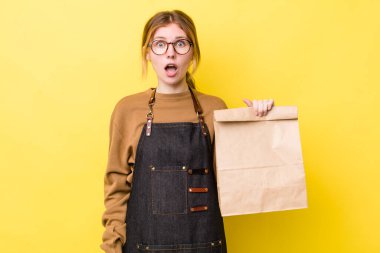 Kızıl saçlı güzel kadın çok şaşırmış ya da şaşkın görünüyor. teslimat paket servis kavramı