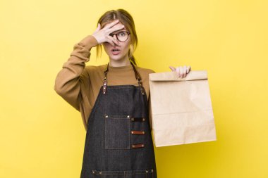 Kızıl saçlı güzel bir kadın şok olmuş, korkmuş ya da korkmuş görünüyor. teslimat paket servis kavramı