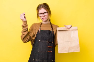 Kızıl saçlı, güzel bir kadın kapiş ya da para hareketi yapıyor, sana ödemeni söylüyor. teslimat paket servis kavramı