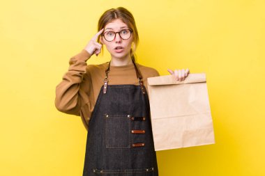 Kızıl saçlı güzel kadın şaşırmış görünüyor, yeni bir düşünce, fikir ya da konsept fark ediyor. teslimat paket servis kavramı