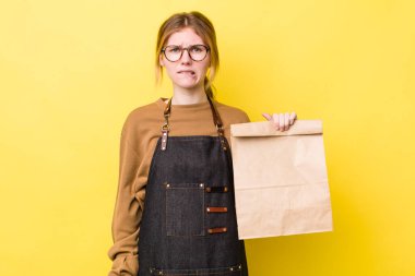 Kızıl saçlı güzel kadın kafası karışık ve şaşkın görünüyor. teslimat paket servis kavramı