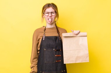 Kızıl saçlı güzel kadın iğrenmiş ve sinirlenmiş hissediyor ve dilini dışarı çıkarıyor. teslimat paket servis kavramı