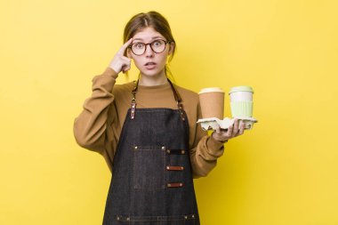 Kızıl saçlı güzel kadın şaşırmış görünüyor, yeni bir düşünce, fikir ya da konsept fark ediyor. kahve konseptini kaldır.