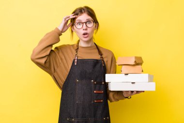 Kızıl saçlı güzel kadın mutlu, şaşkın ve şaşırmış görünüyor. Fast food yumuşak olsun.