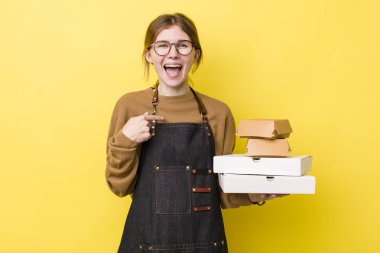 Kızıl saçlı güzel bir kadın mutlu hissediyor ve heyecanla kendini işaret ediyor. Fast food yumuşak olsun.