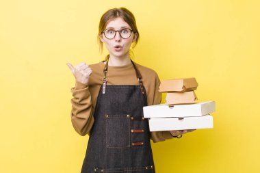 Kızıl saçlı, güzel bir kadın inançsızlıktan şaşkın şaşkın bakıyor. Fast food yumuşak olsun.
