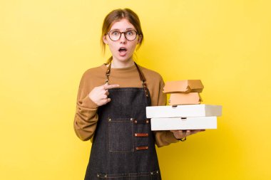 Kızıl saçlı güzel kadın şok olmuş ve ağzı açık, kendini işaret eden bir şekilde şaşırmış görünüyor. Fast food yumuşak olsun.