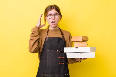 Kızıl saçlı güzel kadın ellerini havaya kaldırarak çığlık atıyor. Fast food yumuşak olsun.