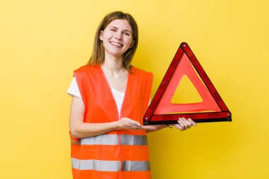 kızıl saçlı güzel bir kadın neşeli bir şekilde gülümsüyor, mutlu hissediyor ve bir konsept gösteriyor. Araba üçgeni tehlikesi