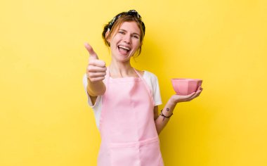 Kızıl saçlı güzel bir kadın gururlu, olumlu gülümsüyor. Ev hanımı elinde boş bir kâse tutuyor.