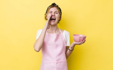 Kızıl saçlı, güzel bir kadın kendini mutlu hissediyordu. Elleri ağzının kenarında bağırıyordu. Ev hanımı elinde boş bir kâse tutuyor.