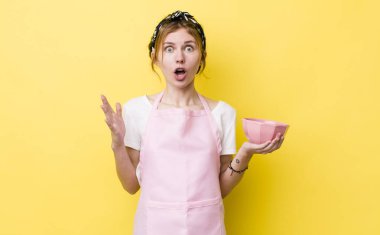 Kızıl saçlı güzel kadın inanılmaz bir sürprizle şaşkına dönmüş ve hayrete düşmüştü. Ev hanımı elinde boş bir kâse tutuyor.