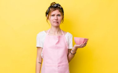 Kızıl saçlı güzel kadın kafası karışık ve şaşkın görünüyor. Ev hanımı elinde boş bir kâse tutuyor.