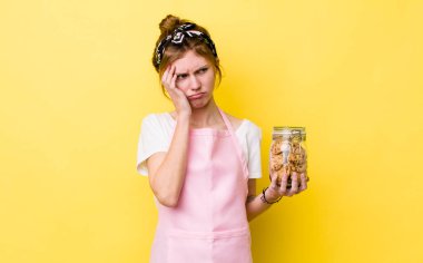 Kızıl saçlı, güzel bir kadın bıkkın, yorgun ve uykulu hissediyor. Ev hanımı elinde kurabiye şişesi tutuyor.