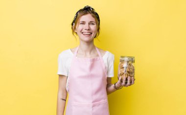 Kızıl saçlı güzel kadın mutlu ve hoş bir şekilde şaşırmış görünüyor. Ev hanımı elinde kurabiye şişesi tutuyor.