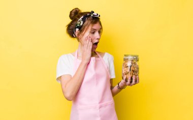 red head pretty woman feeling happy, excited and surprised. housewife holding a cookies bottle