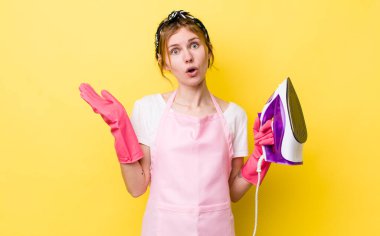 Kızıl saçlı, güzel bir kadın şaşırmış ve şok olmuş görünüyor. Çenesi düşmüş, elinde bir nesne var. kahya konsepti