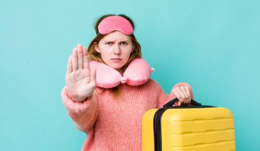 Kızıl saçlı güzel kadın ciddi görünüyor. Avuç içini gösteriyor. Durdurma hareketi yapıyor. uçuş yolcu kavramı