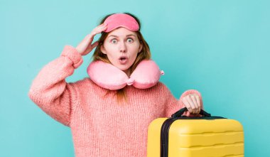 Kızıl saçlı güzel kadın mutlu, şaşkın ve şaşırmış görünüyor. uçuş yolcu kavramı