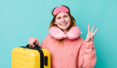 Kızıl saçlı güzel kadın gülümsüyor ve arkadaş canlısı görünüyor, üç numarayı gösteriyor. uçuş yolcu kavramı