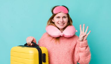 Kızıl saçlı güzel kadın gülümsüyor ve arkadaş canlısı görünüyor, dört numarayı gösteriyor. uçuş yolcu kavramı