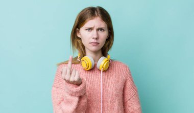 Kızıl saçlı güzel bir kadın kızgın, sinirli, asi ve agresif hissediyor. kulaklıklar ve müzik konsepti