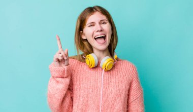 Kızıl saçlı, güzel bir kadın bir fikri fark ettikten sonra mutlu ve heyecanlı bir dahi gibi hissediyor. kulaklıklar ve müzik konsepti